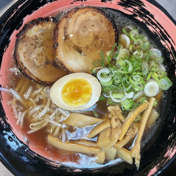 Mako Ramen bowl with chashu pork, a soft-boiled egg, scallions, bean sprouts, and bamboo shoots.