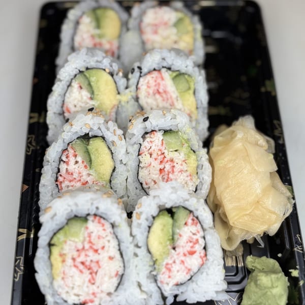 Eight California rolls with avocado and crab, served with ginger and wasabi in a black tray.