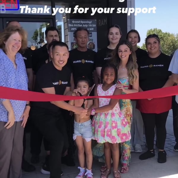 Mako Ramen staff and two children cut a red ribbon for the grand opening celebration.