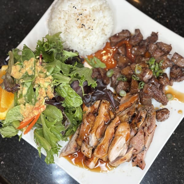 A Mako Ramen bento box with teriyaki chicken, beef, rice, and a side salad.